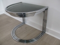 A nest of 3 chrome & glass, semicircular tables
