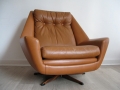 A large tan leather Danish swivel chair